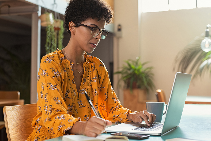 Une jeune femme utilise son portable et son téléphone cellulaire pour prendre contact avec le milieu de son stage à venir et à se renseigner sur le milieu et la clientèle