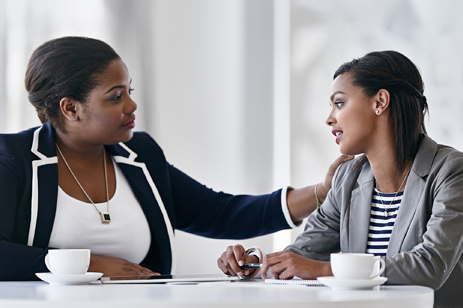 Une conversation entre une superviseure et sa stagiaire. La stagiaire pose ses mains sur les épaules de la patiente