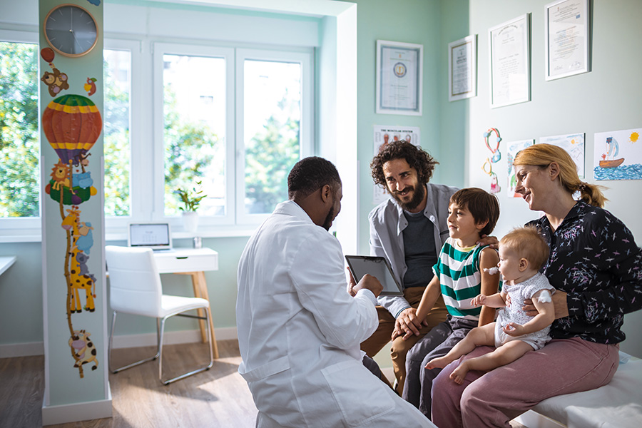 Un professionnel de la santé discute avec un couple et ses deux enfants.