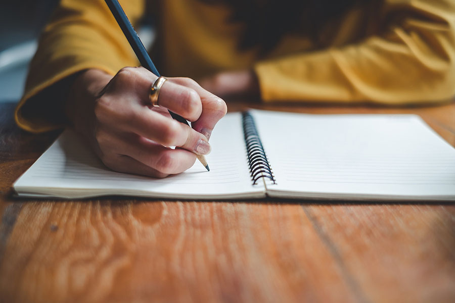 Une femme écrit dans un carnet de notes