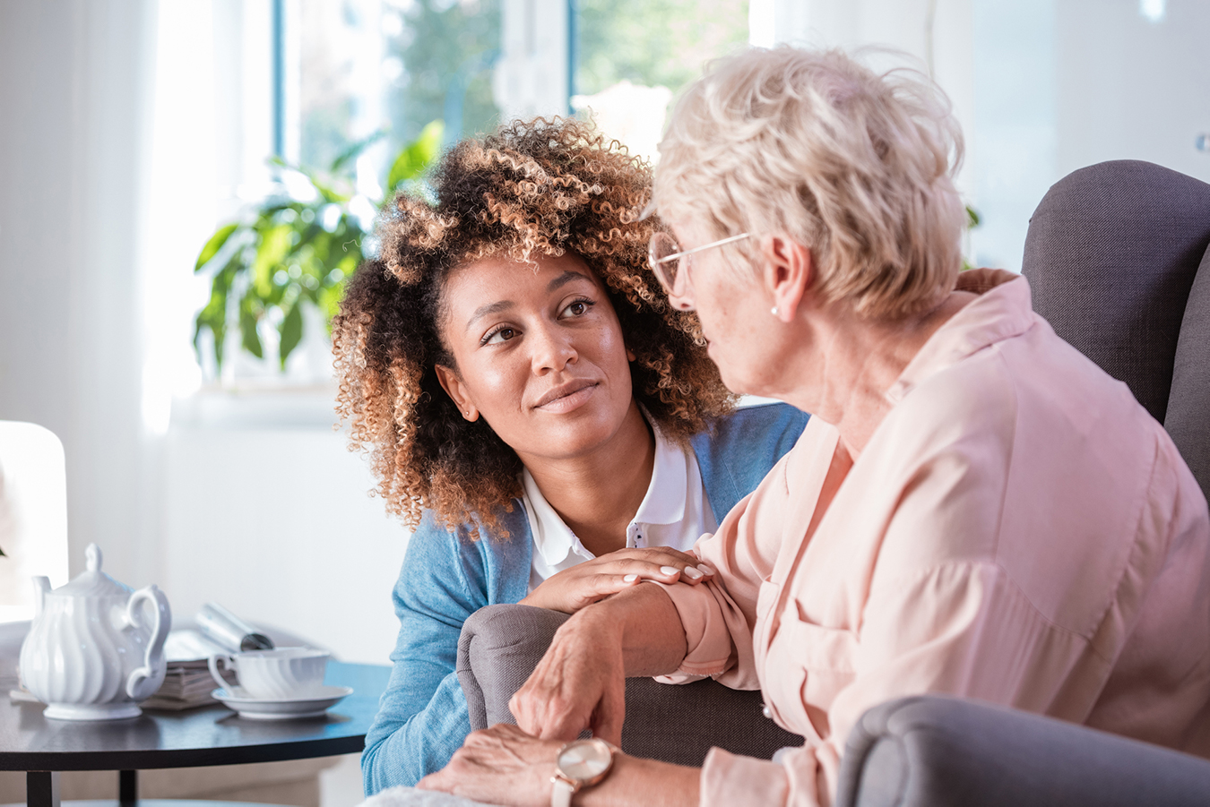 Une professionnelle pose sa main sur l’avant-bras d’une personne âgée