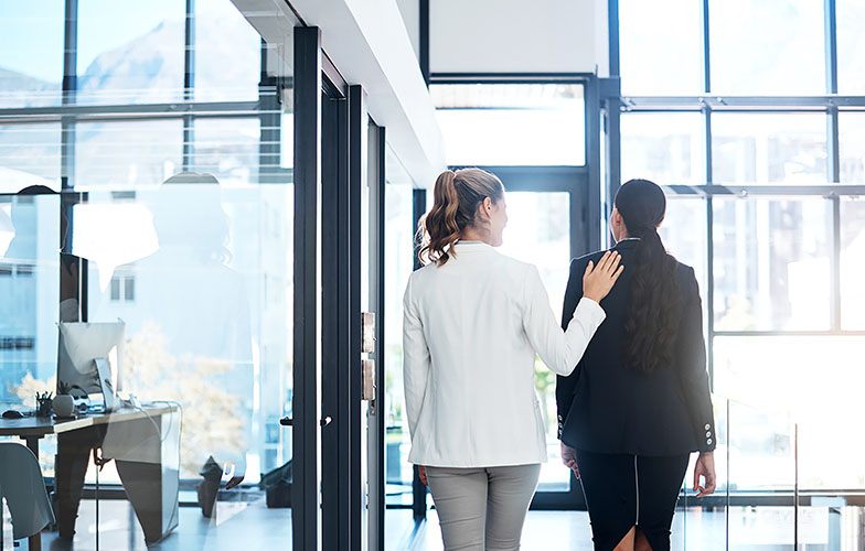 une professionnelle pose sa main dans le dos  d’une femme en signe de réconfort