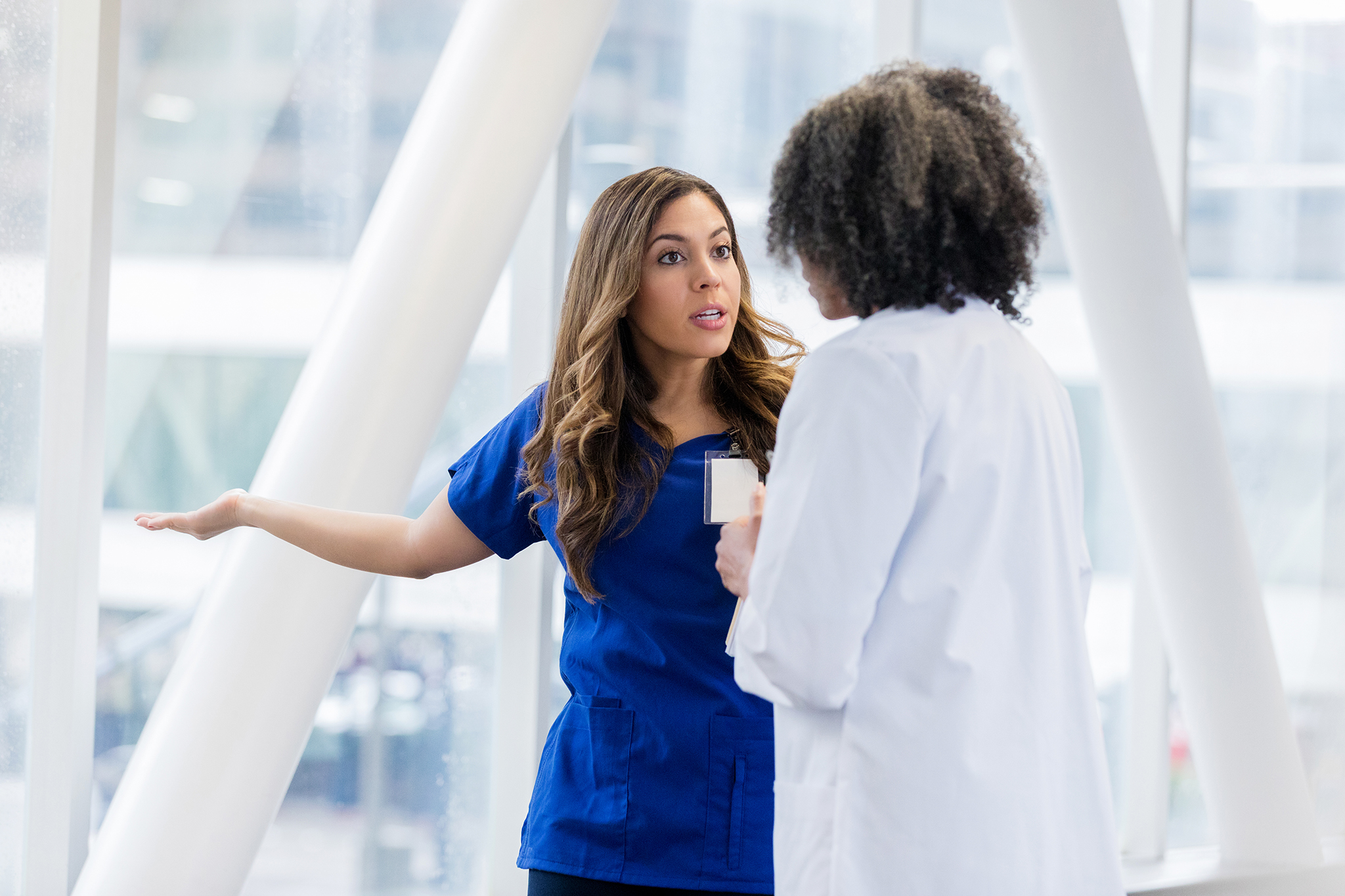 Une professionnelle démontre un langage non verbal exprimant un désaccord devant une autre professionnelle