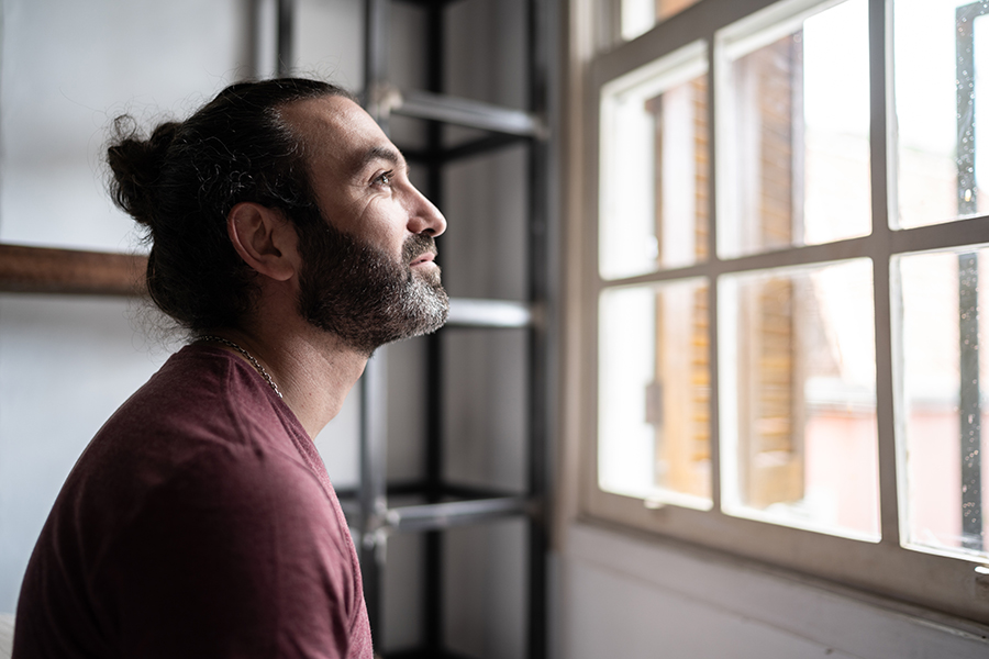 Un homme pensif regarde par la fenêtre