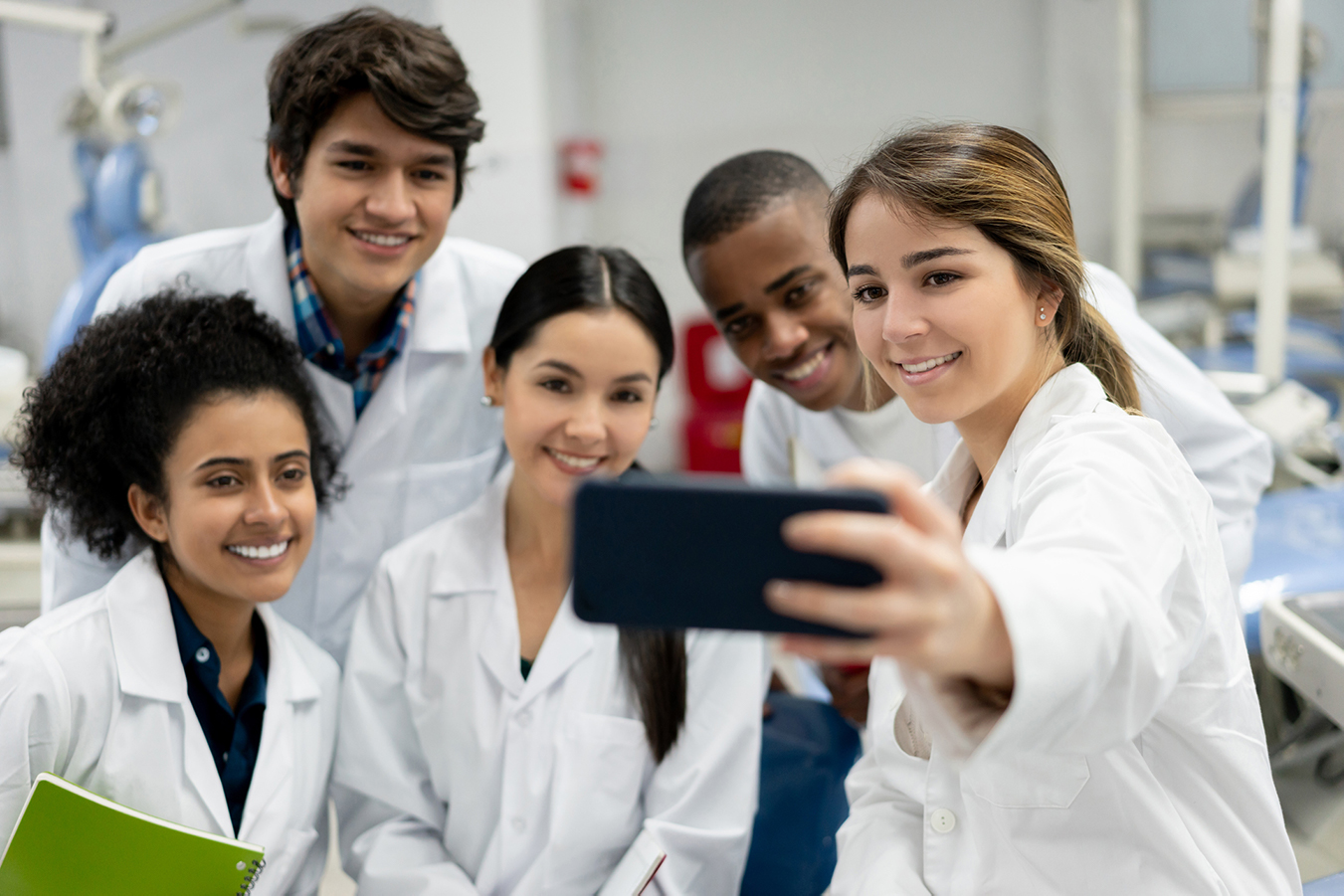 Un groupe d’étudiants regardent l’écran d’un cellulaire.