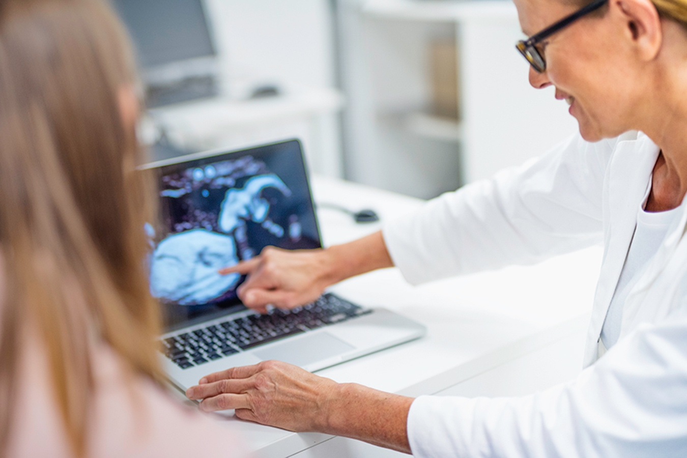 Une femme pointe des résultats de tests diagnostiques sur son portable.