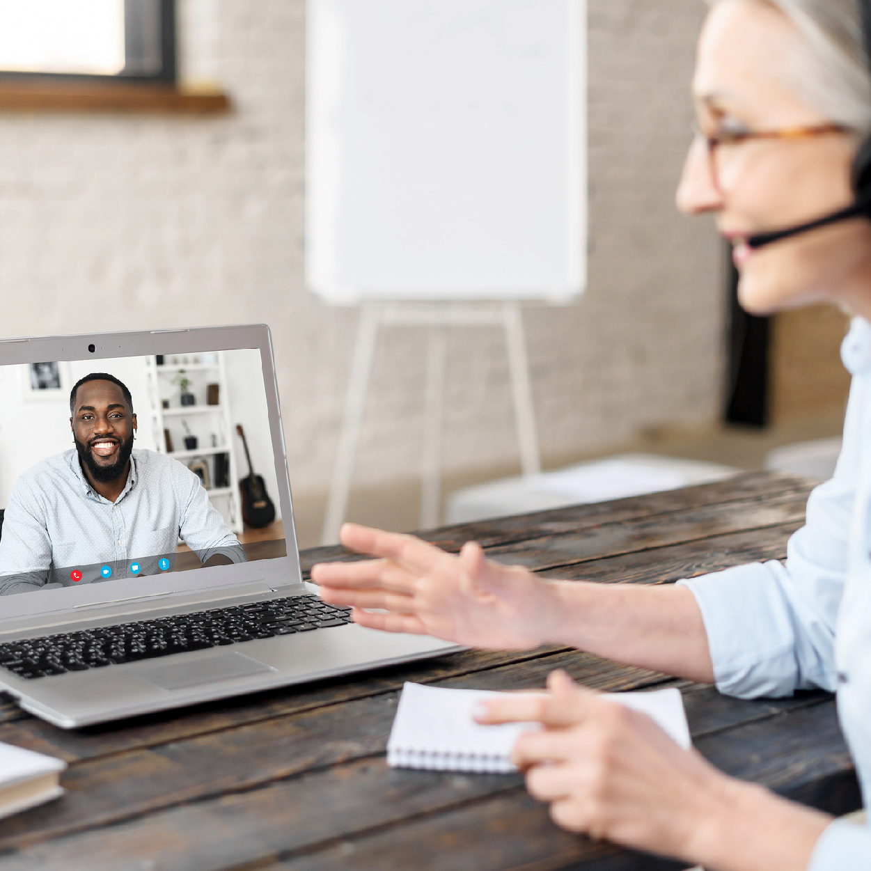 Une superviseure expérimentée portant un casque parle à son stagiaire dans son milieu de stage à distance