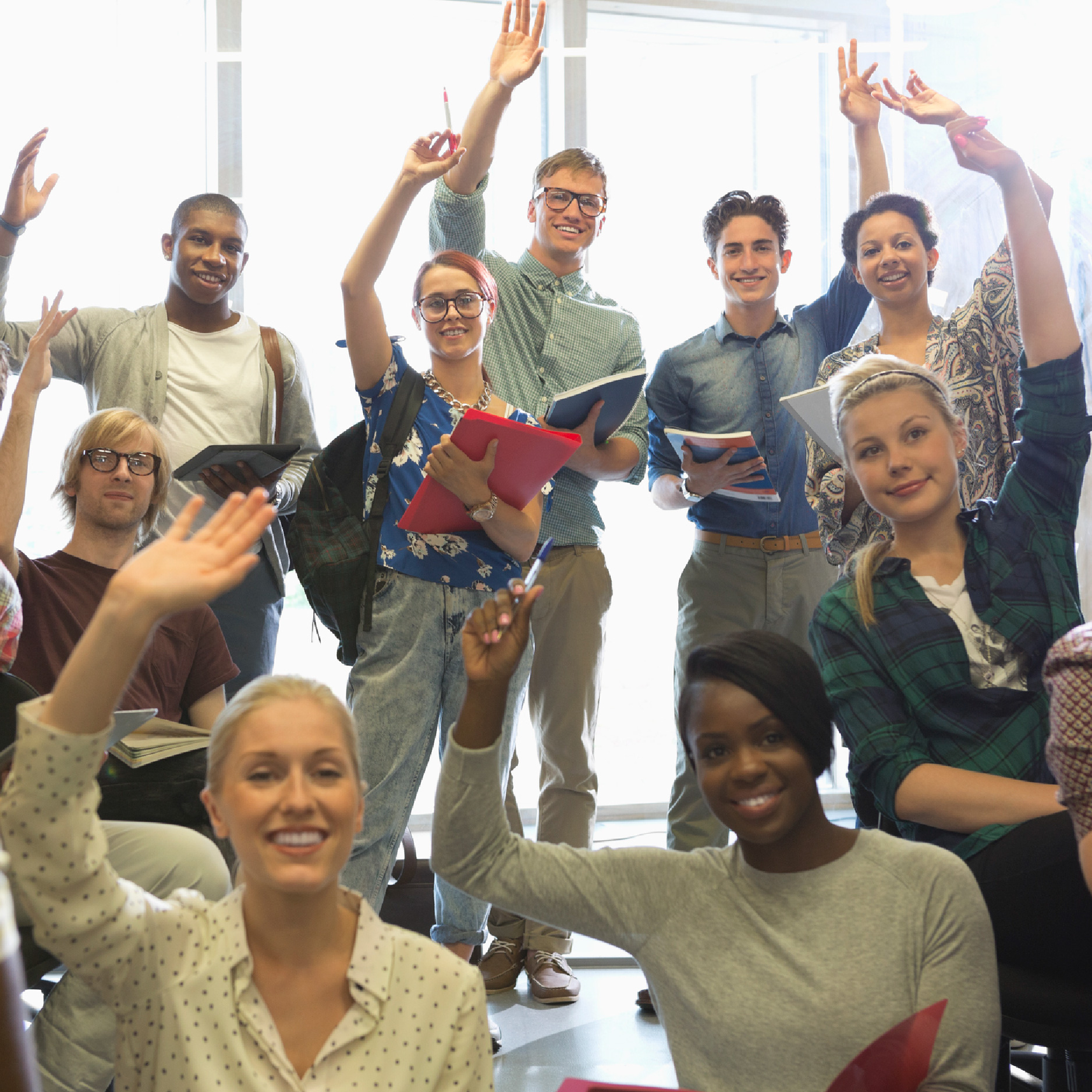 Un groupe de 12 stagiaires ont tous les mains levées