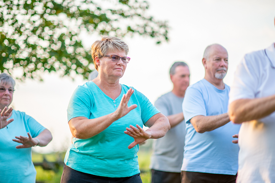 Un groupe d'hommes et de femmes ayant la soixantaine font du Tai Chi