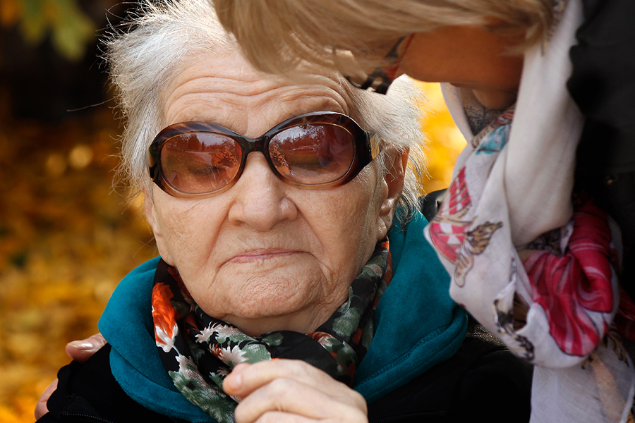 Une clinicienne avec sa main sur l'épaule de sa patiente, une personne âgée hémiplégique