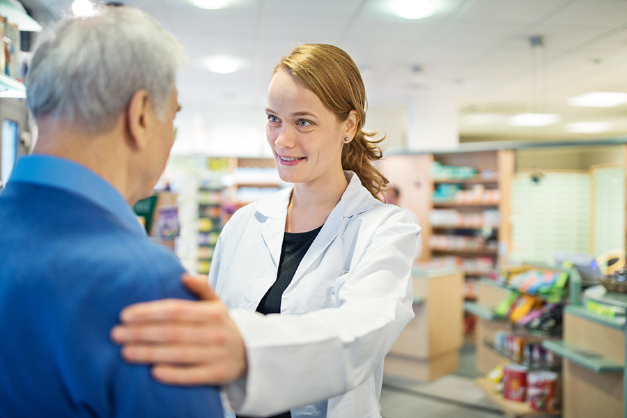 Une clinicienne, avec sa main sur le bras de son patient, regarde droit dans ses yeux