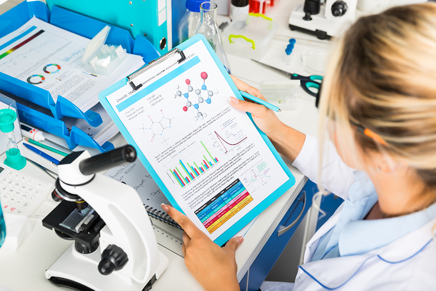 Une clinicienne lit les données de la recherche scientifique