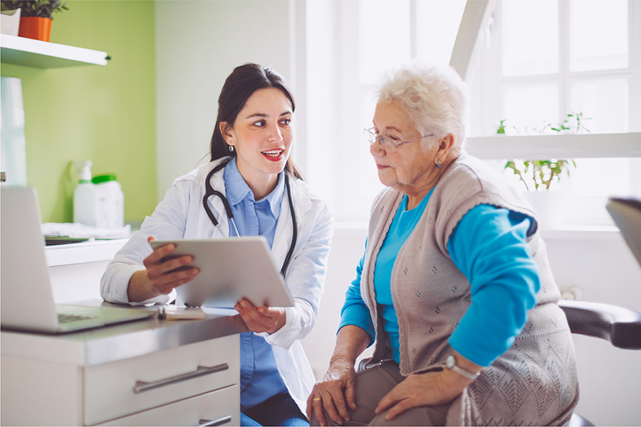Une clinicienne tient une tablette et discute les preuves scientifiques avec sa patiente