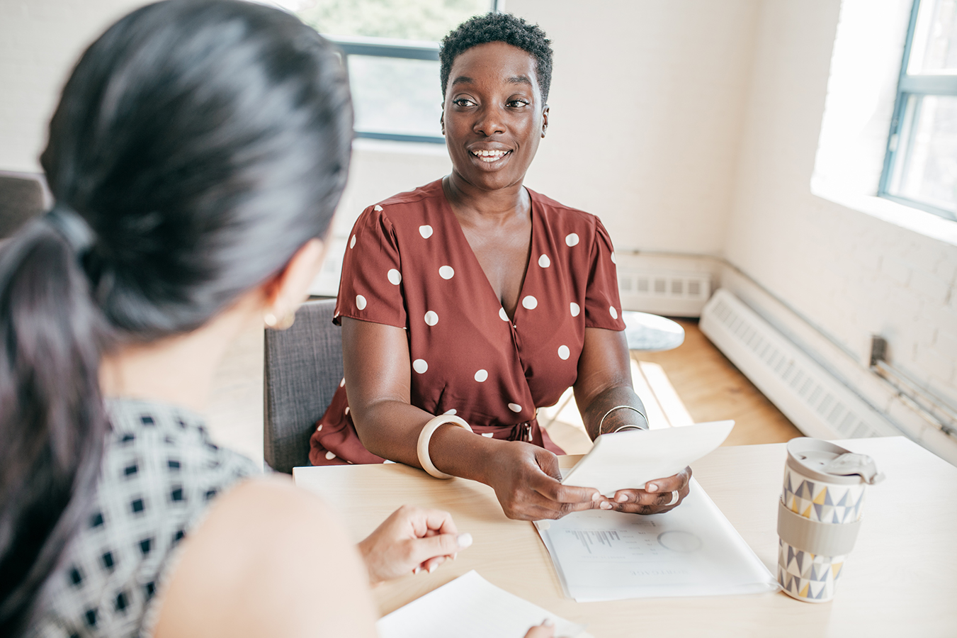 A supervisor gives feedback to her trainee