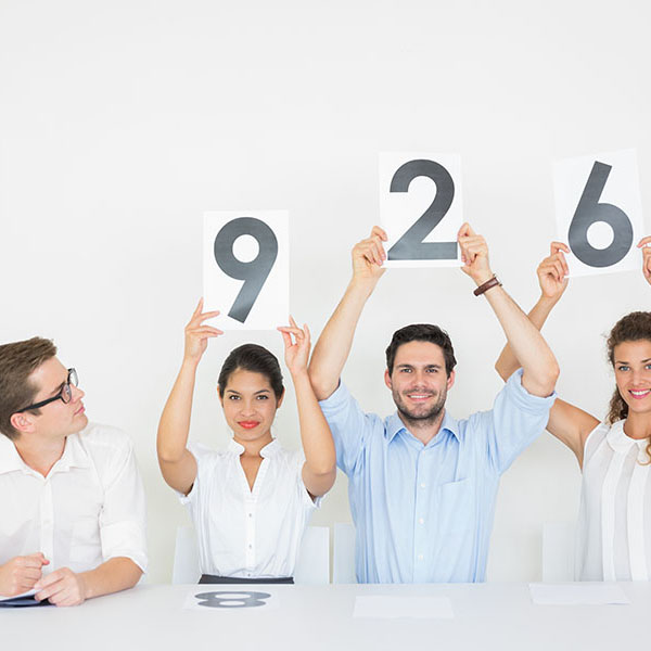 In plain view, assessors display different marks written on a paper they hold above their heads