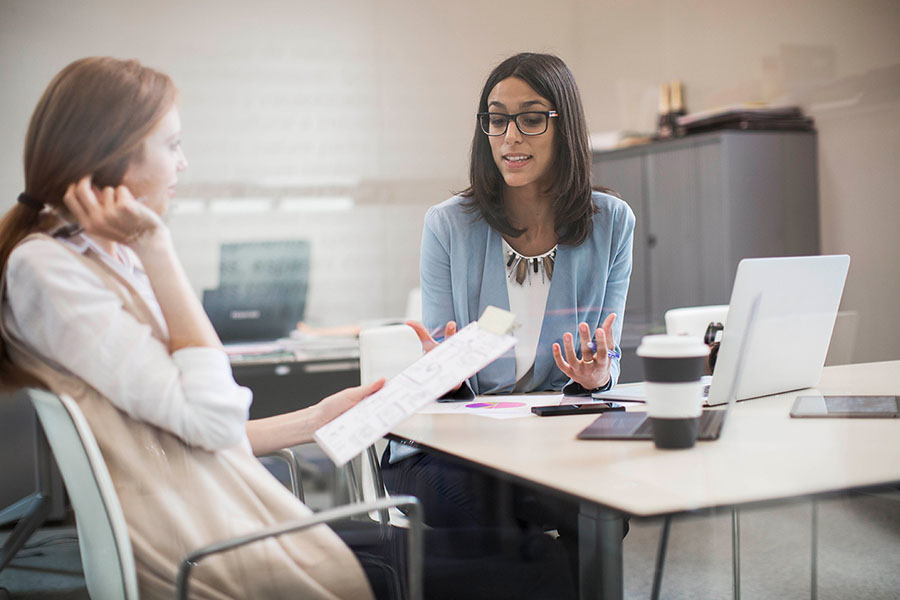 A supervisor has a conversation with her trainee.